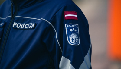 Policista pleca tuvplāns, dienesta ģerbonis un uzraksts policija baltiem burtiem uz zilgana fona