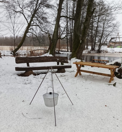 Soliņš un galds pie ugunskura vietas, fonā Zasas upe
