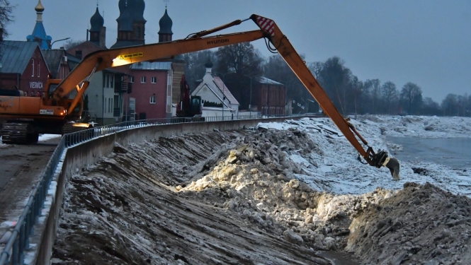 Ekskavators uz dambja pie Daugavas