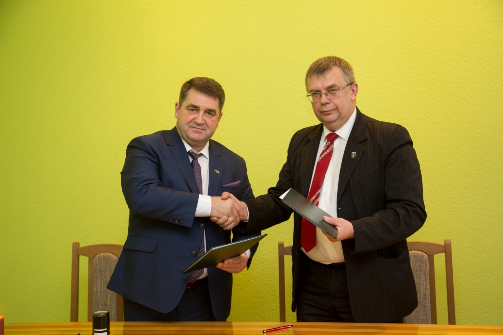 Kupišķu mērs un Aivars Vanags paspiež rokas pēc līguma parakstīšanas