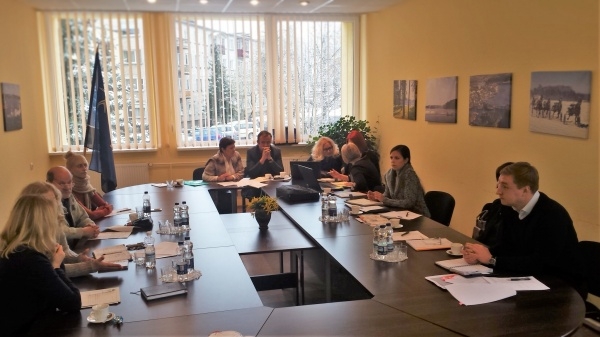 Notiek projektu apspriede pie galda vairākiem cilvēkiem piedaloties