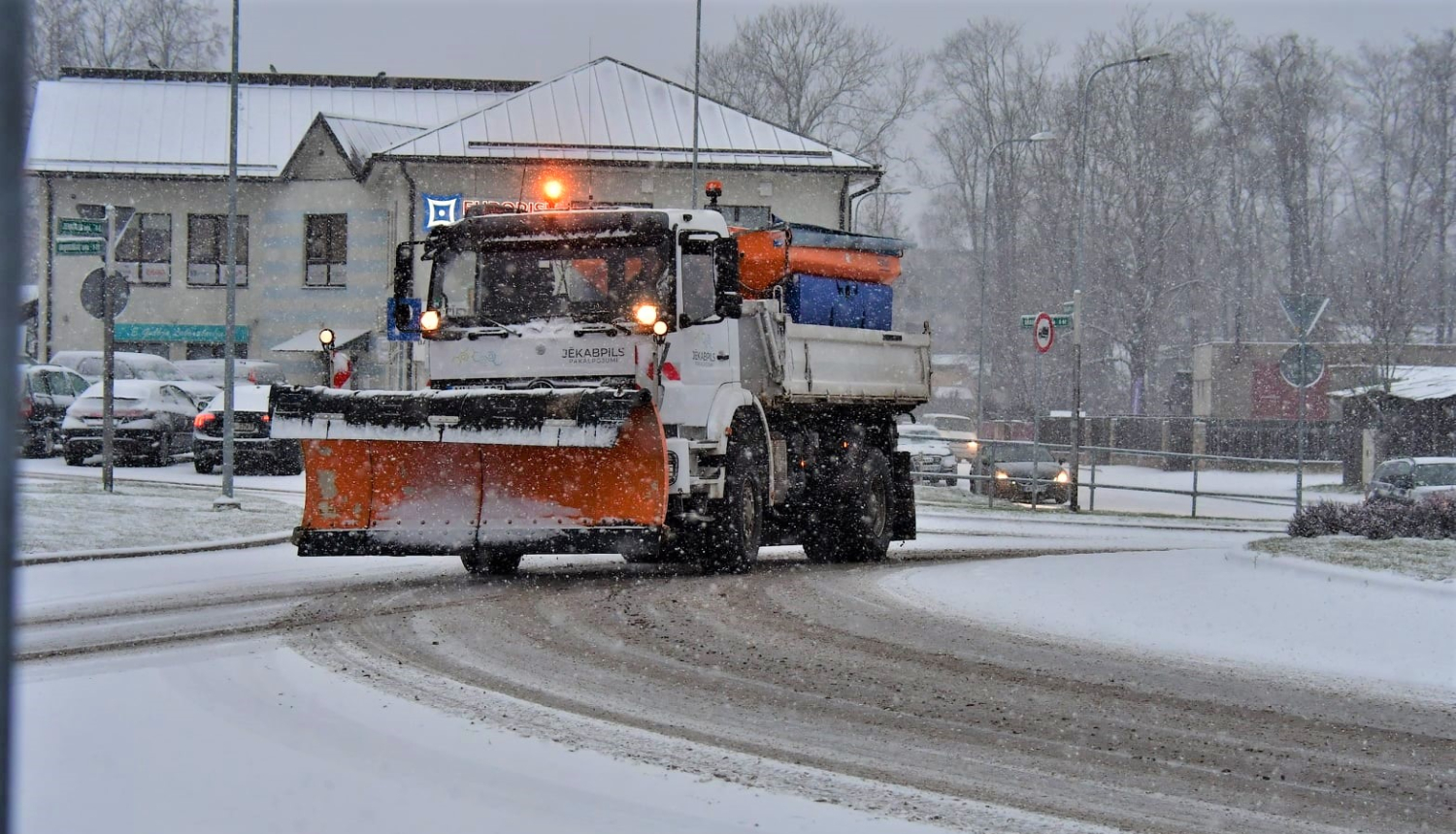 Jēkabpils pakalpojumi sniega tīrītājs brauc pa apsnigušu rotācijas apli