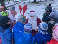 Ziemassvētku vecītis sniedz bērniem dāvanas