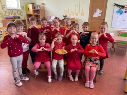 Rubeņu pamatskolas skolēni sēž kopā telpā, rāda ar rokām sirdis