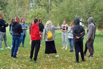 Projekta publicitātes foto - jaunieši stāv aplī ārā un komunicē