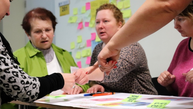 Personas sēž pie galda apmācībās