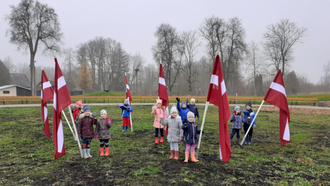 Skolēni pie Latvijas karogiem Saules skvērā Rubeņos
