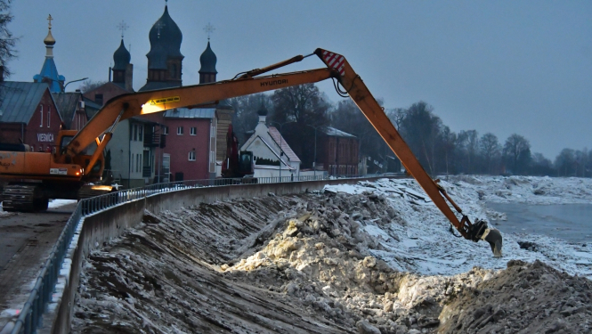 Ekskavators uz dambja pie Daugavas