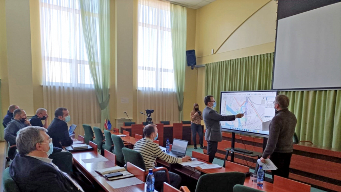 Civilās aizsardzības mācības sēžu zālē Krustpili, tiek rādīta karte uz ekrāna, komisijas locekļi skatās un spriež iespējamās darbības