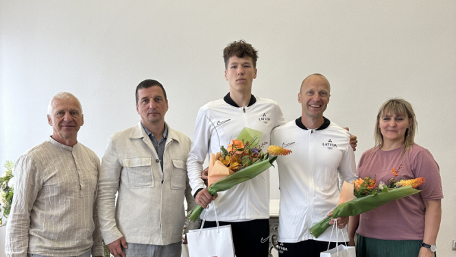 priekšsēdētājs sveic augstlēcēju Danielu Ģiedri