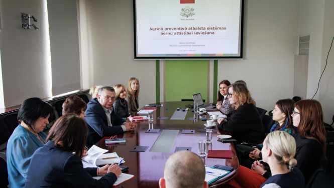 Institūciju pārstāvji sēž pie galda gatavi skatīties prezentāciju