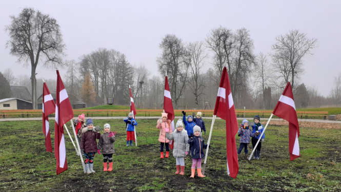 Skolēni pie Latvijas karogiem Saules skvērā Rubeņos