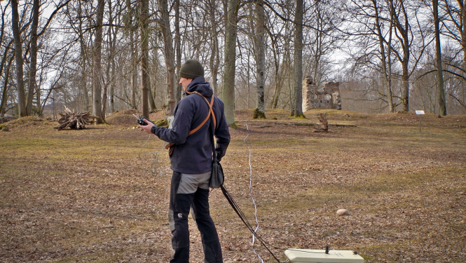 Pētnieks ar ģeoradaru skenē zemi pie Zasas muižas pilsdrupām