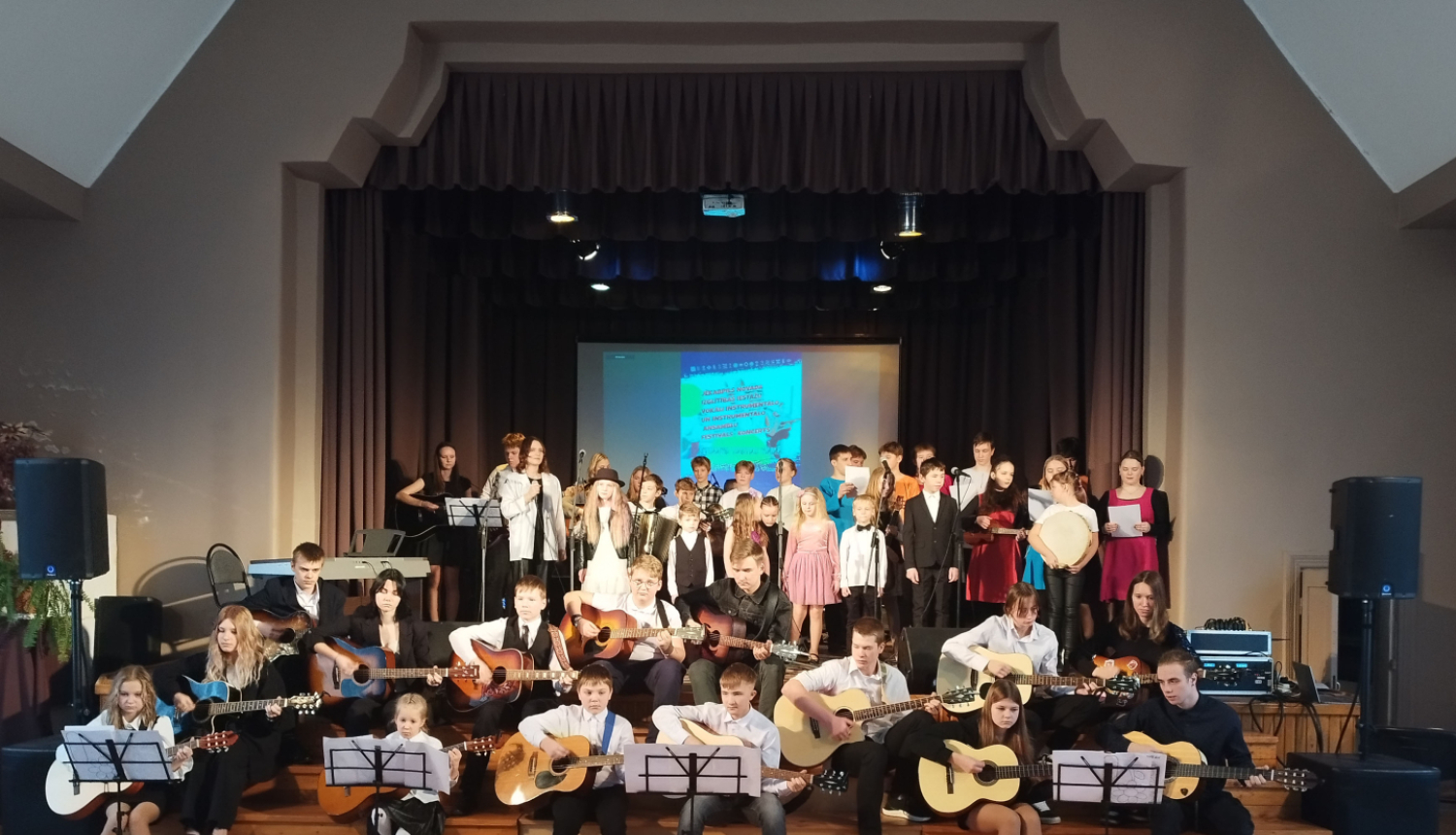 Visi sarīkojuma dalībnieki uzstājas kopā uz skatuves un sēdus uz trepēm