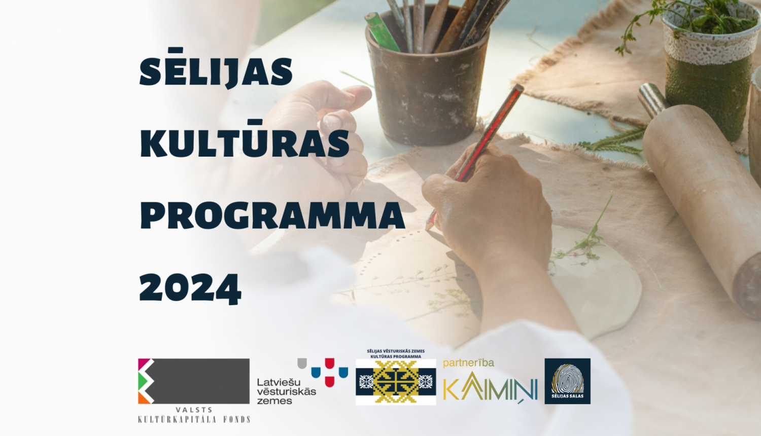 Teksts uz gaiša fona, fonā persona kaut ko skicē uz galda, lejpusē projekta logo ansamblis