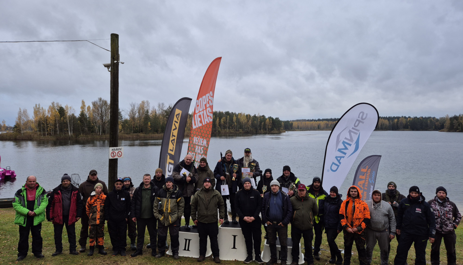Pasākuma dalībnieku kopbilde pie ūdenskrātuves