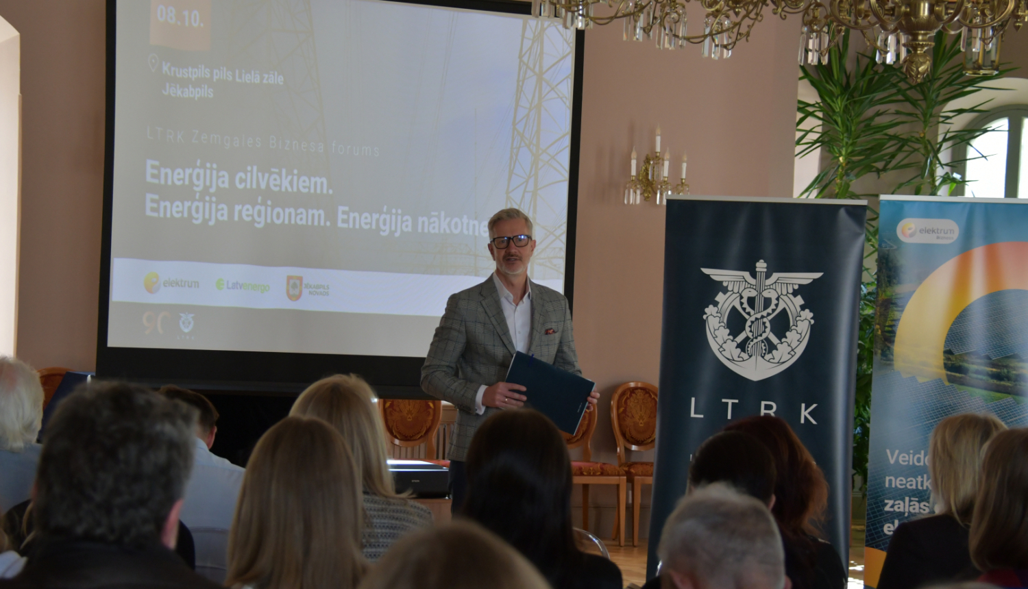 Vadītājs uzrunā publiku zālē