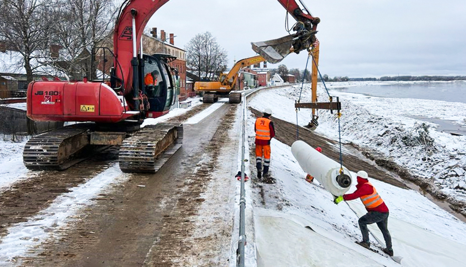 Ekskavators ceļ māla loksnes nostiprināšanai uz Jēkabpils dambja