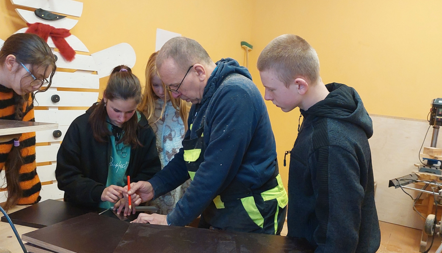 Skolēnu mājturības kabinetā vēro skolotāja darbības ar plāksni