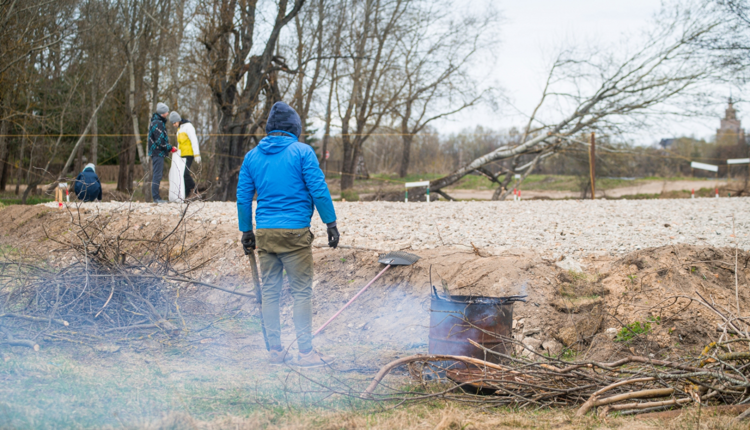 Publicitātes foto no 2021. gada, kurā cilvēks ceļa malā dedzina zaru čupu