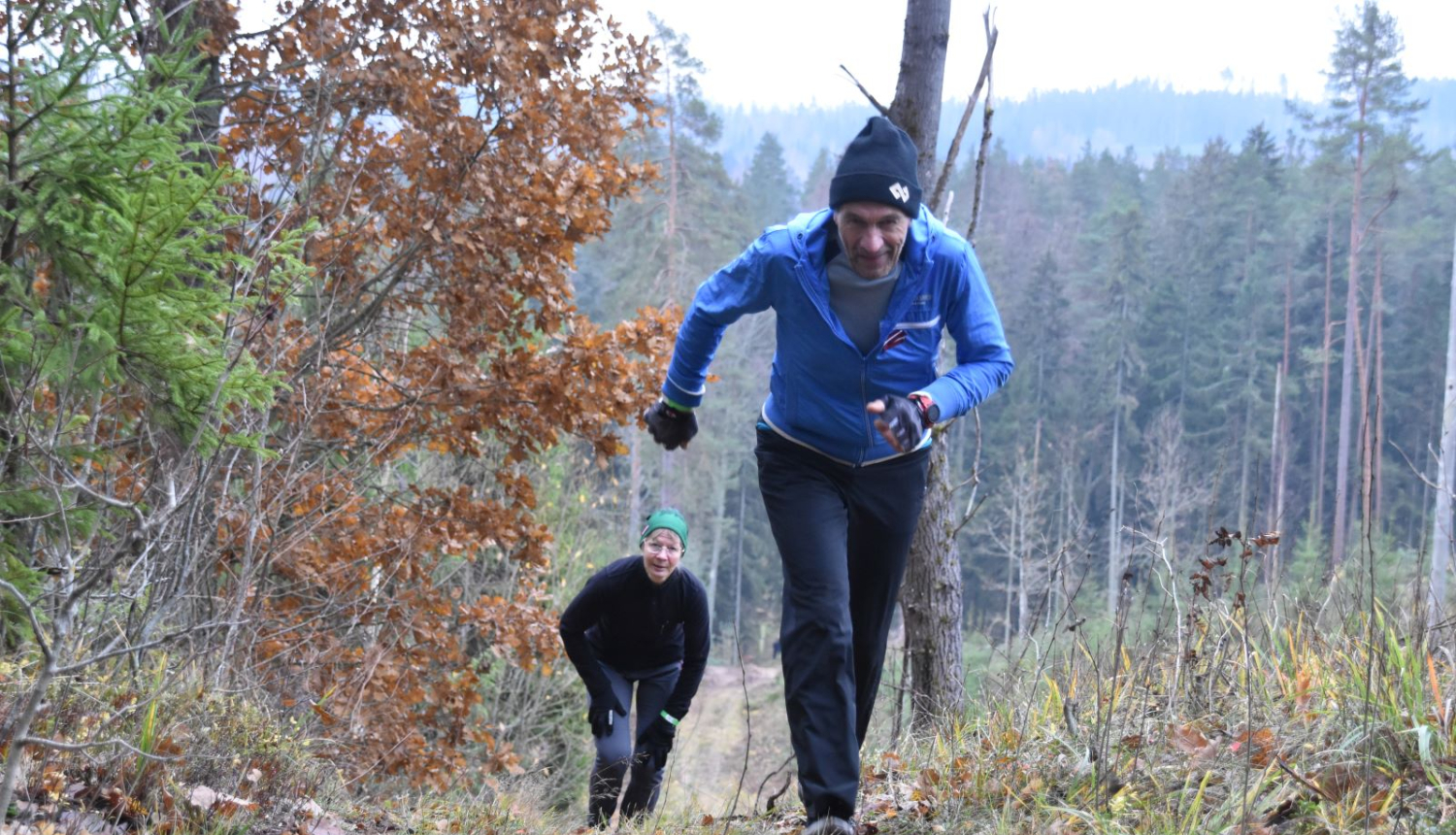 Cilvēks skrien pretī kamerai stāvā kalnā