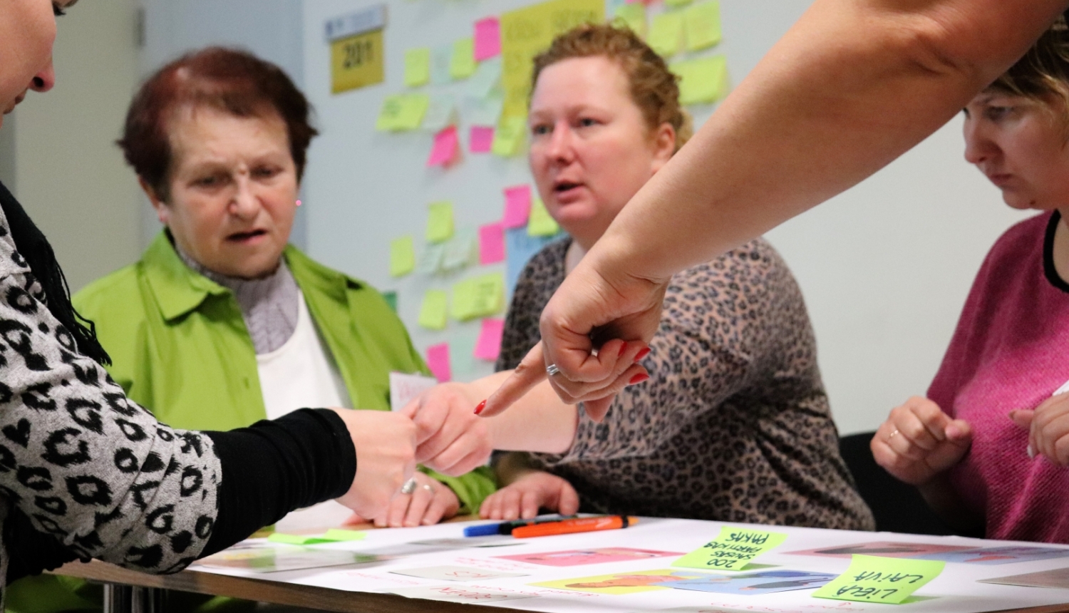 Personas sēž pie galda apmācībās