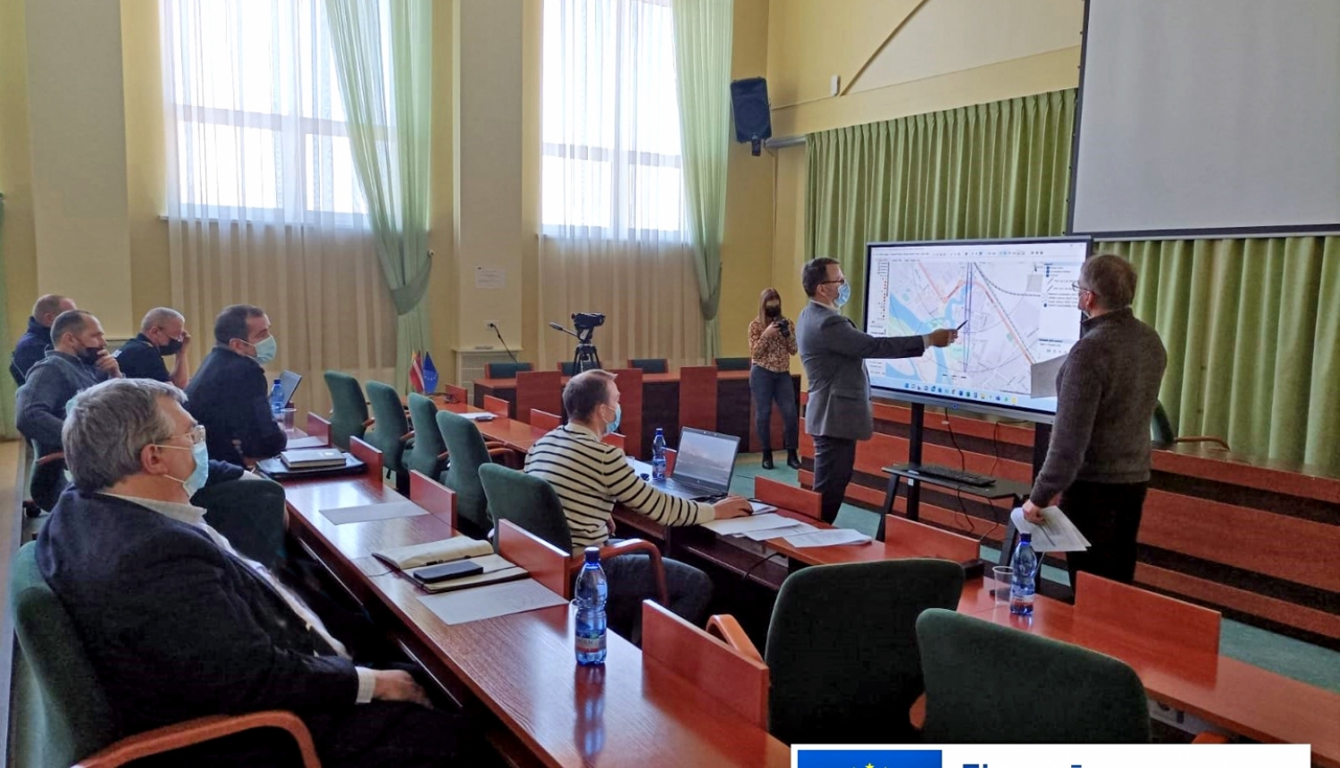Civilās aizsardzības mācības sēžu zālē Krustpili, tiek rādīta karte uz ekrāna, komisijas locekļi skatās un spriež iespējamās darbības