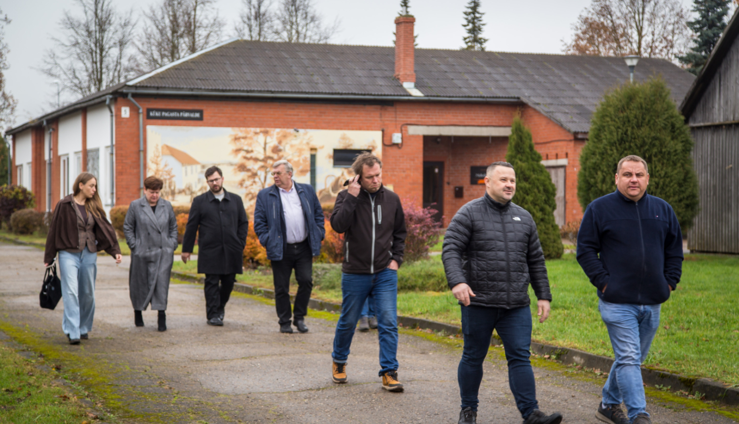 Deputāti iet pret kameru, fonā pagasta pārvaldes ēka