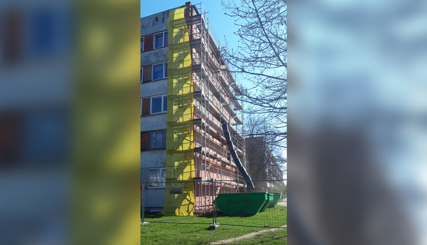 Daudzdzīvokļu māja pavasarī ar sastatnēm sānā