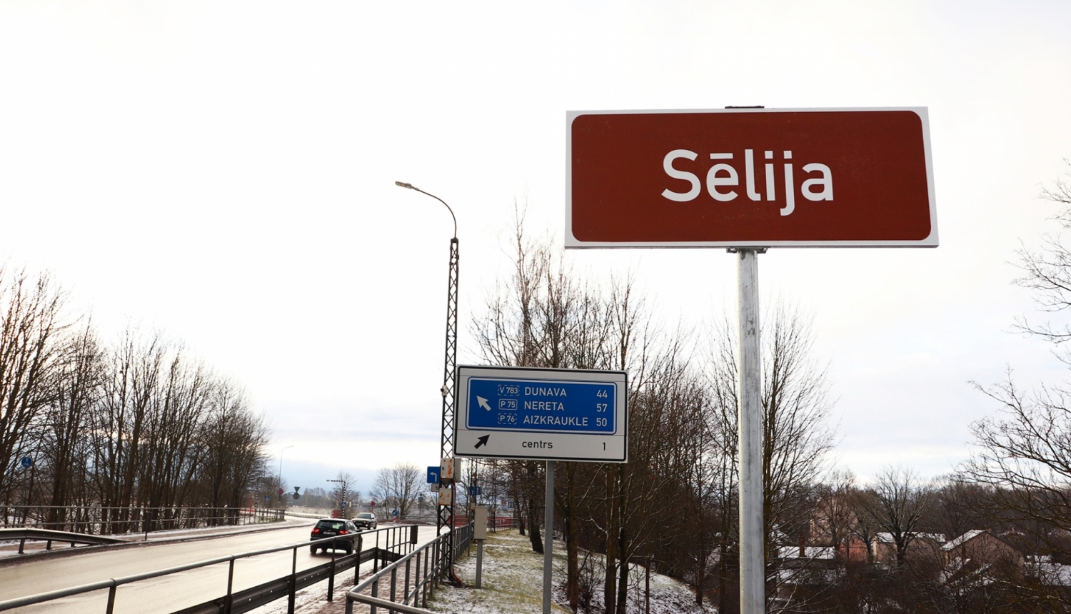 Ceļazīme Jēkabpils tilta malā ar uzrakstu "Sēlija" uz tumši brūna fona plāksnītes