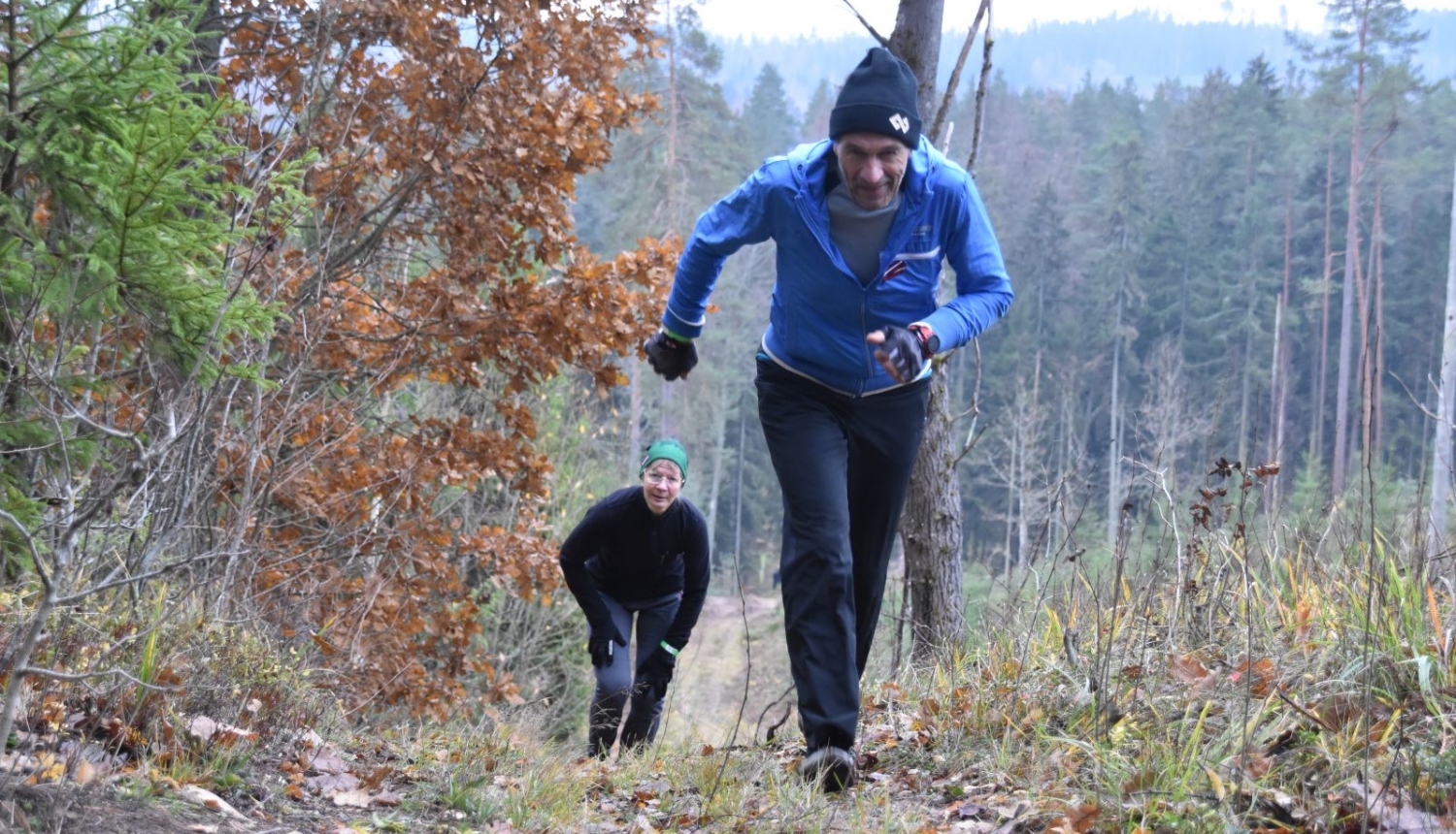 Cilvēks skrien pretī kamerai stāvā kalnā