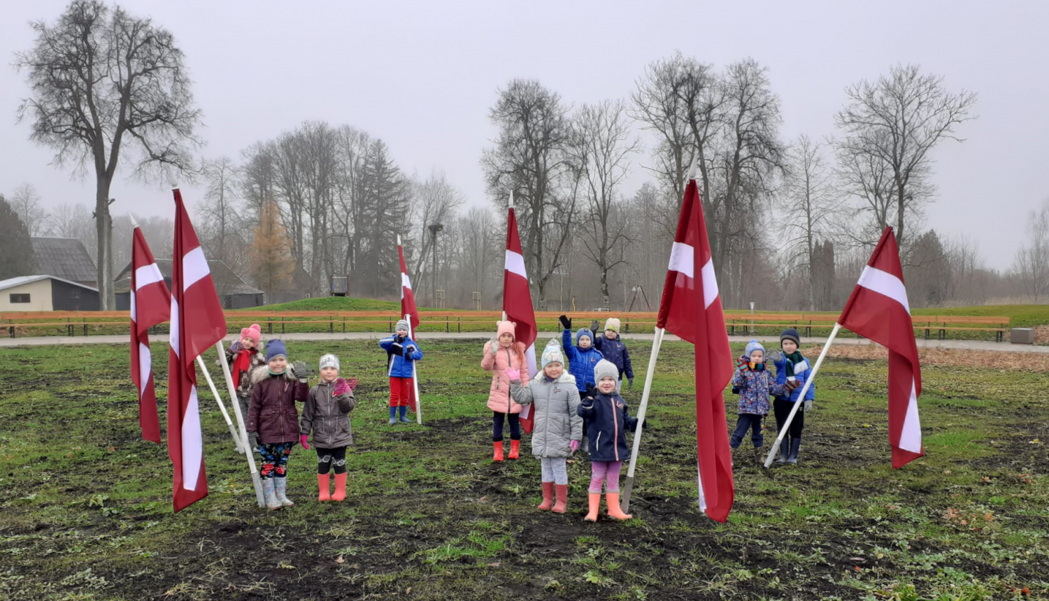 Skolēni pie Latvijas karogiem Saules skvērā Rubeņos
