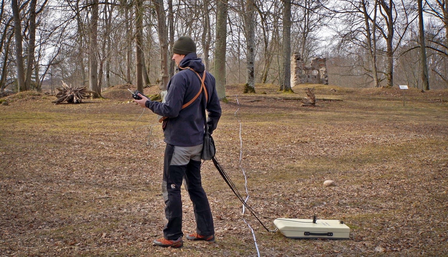 Pētnieks ar ģeoradaru skenē zemi pie Zasas muižas pilsdrupām